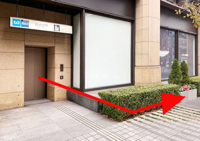 日比谷クリニック順路、黒い壁を通り越し、白い壁の入口をすぐ右へ曲がります